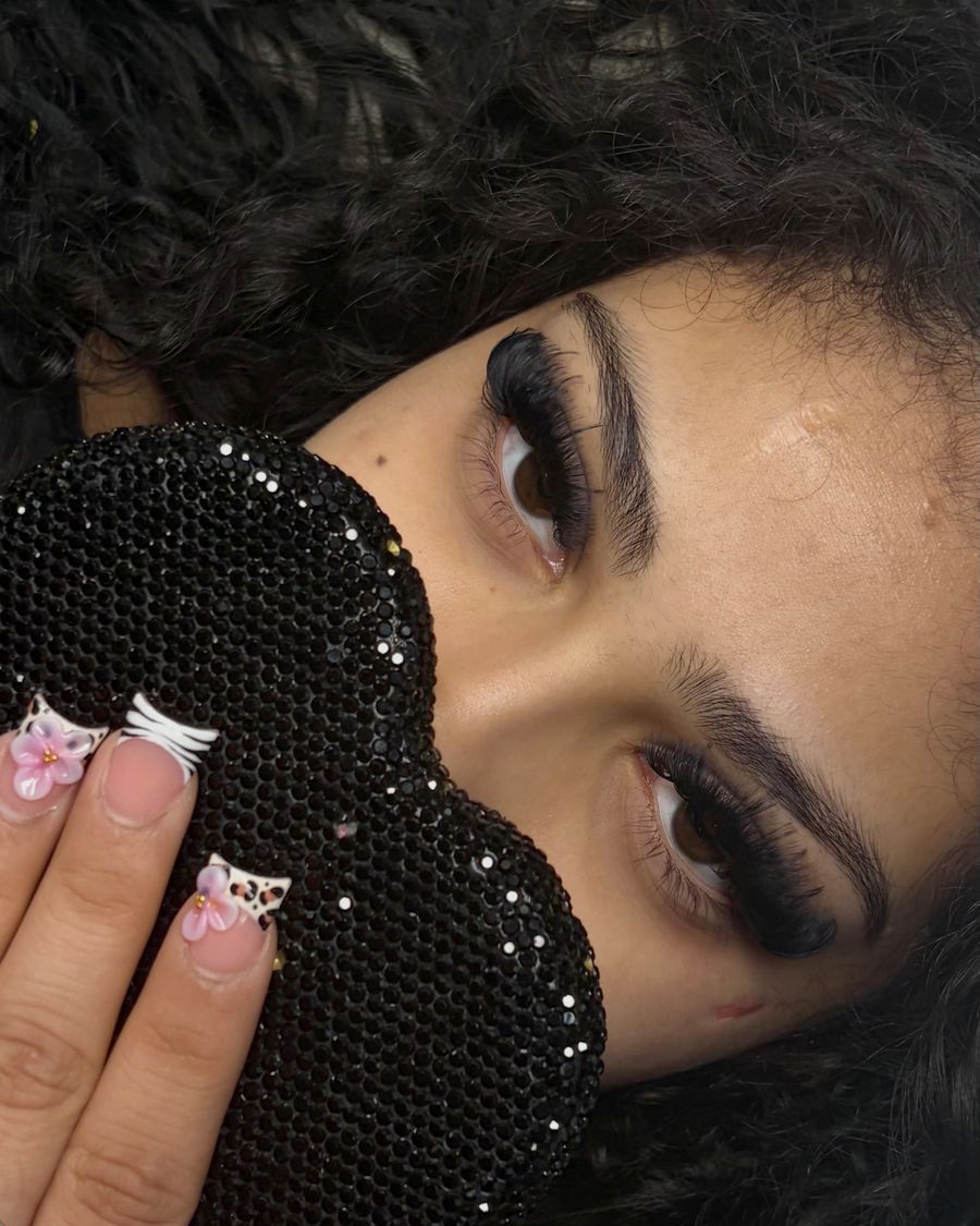 Lash set with french tip nails holding the heart